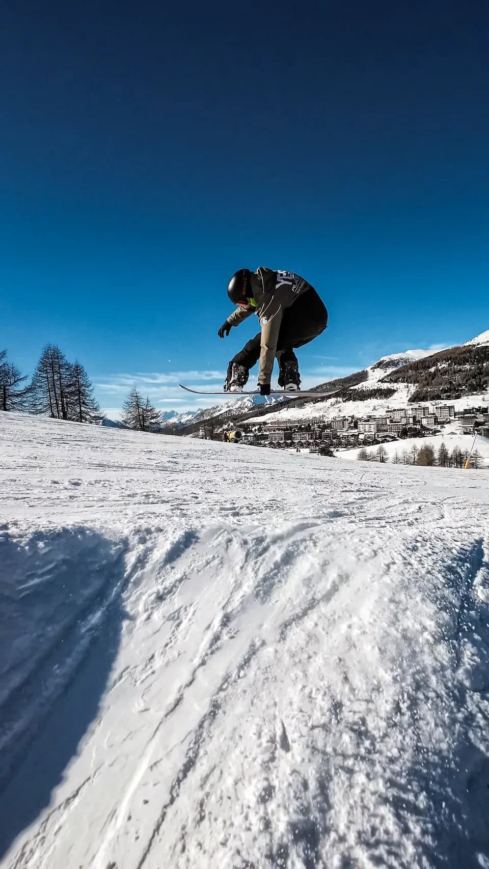 Maestro di YES Academy fa un salto 360 con grab. Giornata di sole e Sestriere sullo sfondo