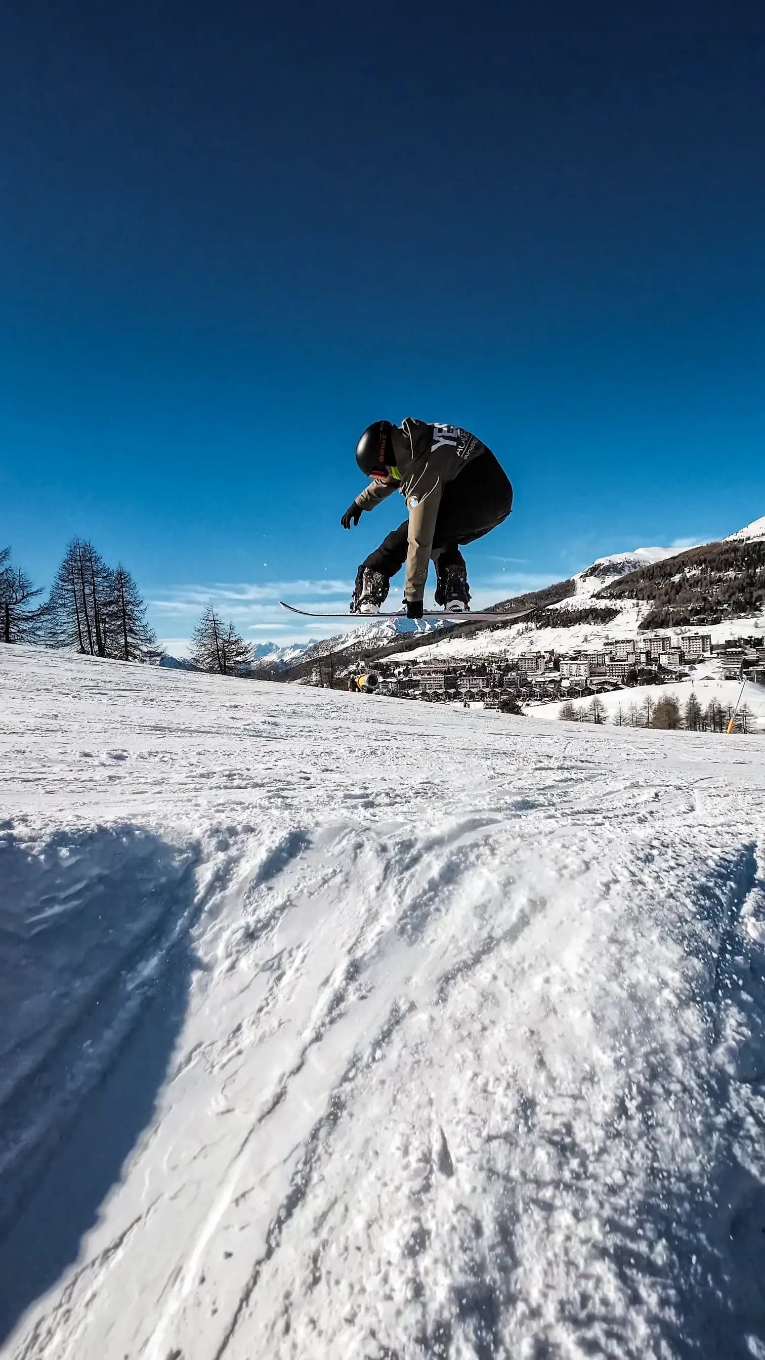 Maestro di YES Academy fa un salto 360 con grab. Giornata di sole e Sestriere sullo sfondo